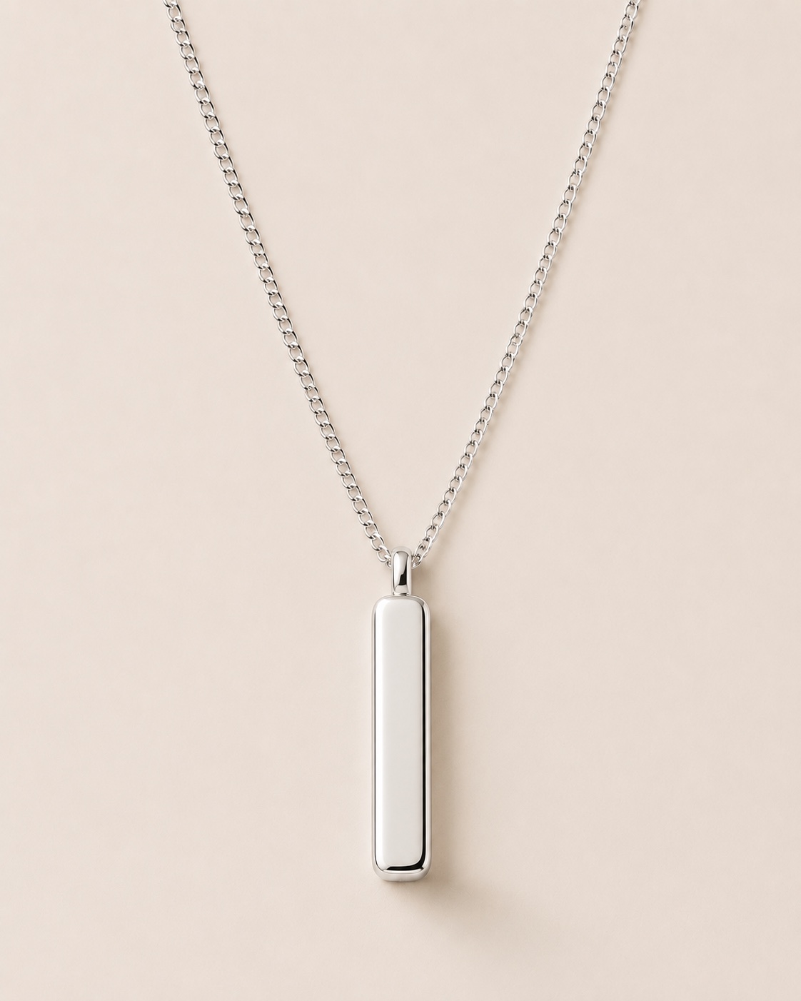 Line Pendant and silver chain on a warm white background
