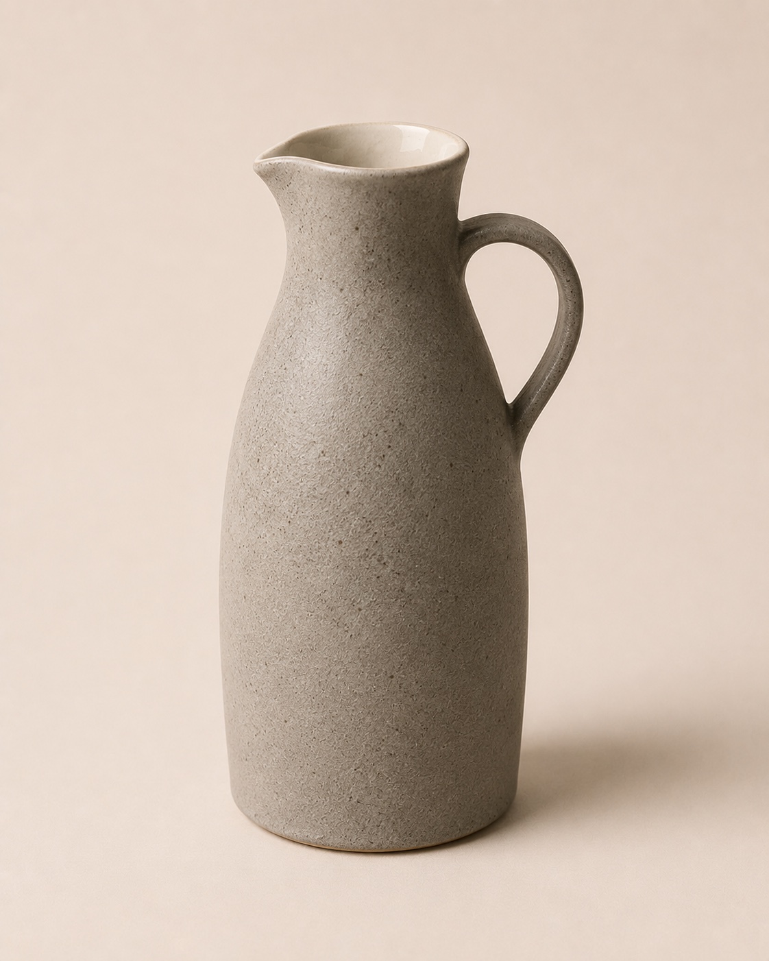 Stoneware Carafe with a curved handle and textured warm-grey glaze
